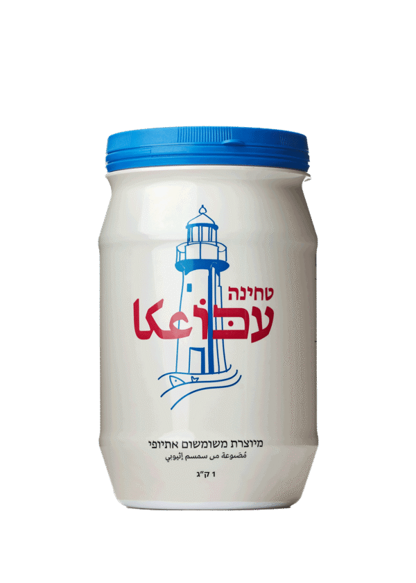 טחינה עכו, מארז 1 ק"ג, שומשום אתיופי, מכל לבן עם מכסה כחול ואיור מגדלור.